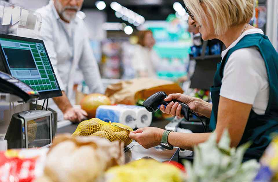 Photo d'une caissière qui scanne des articles au supermarché